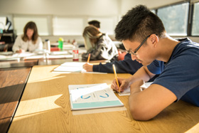 student writing in a classroom