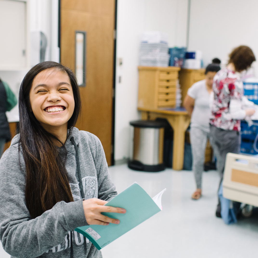 student smiling in a nursing lab
