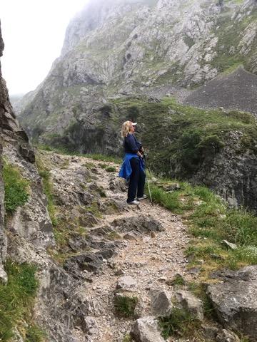 woman standing on a rocky mountain trail