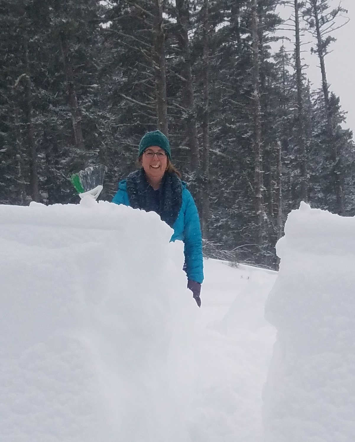 Cindy Trussell standing behind a tall snowbank