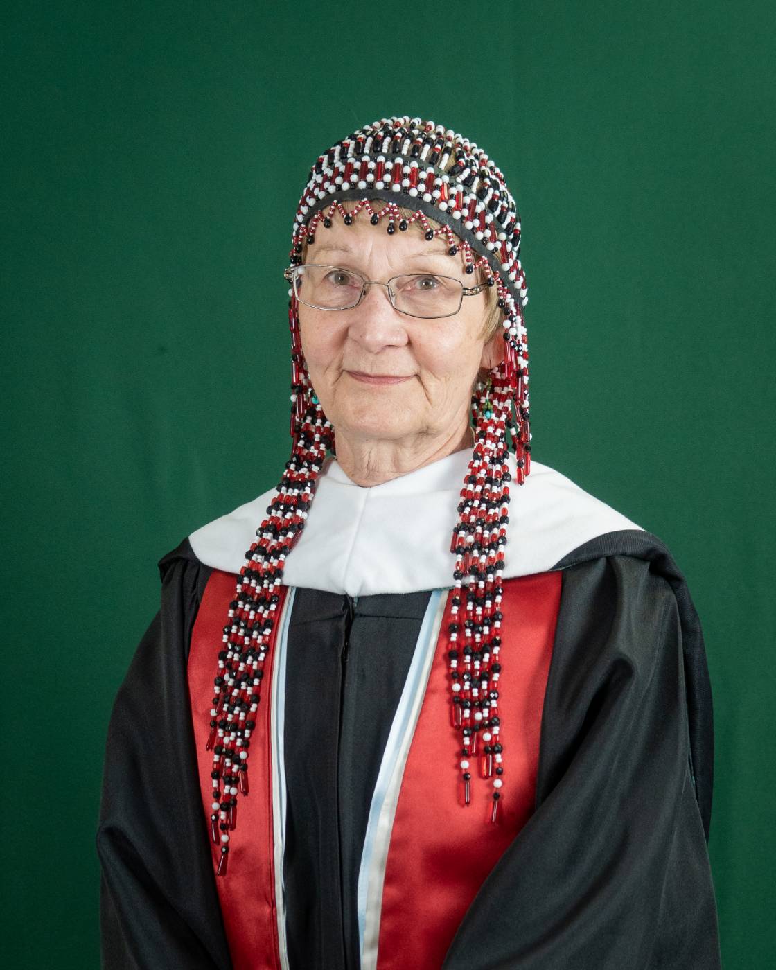 Susan Malutin wearing a ceremonial Alutiiq headpiece and doctoral robes