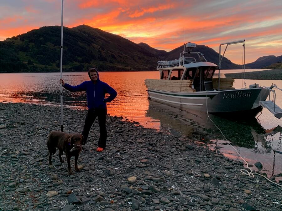 meghan kelly standing on a rocky beach with a dog