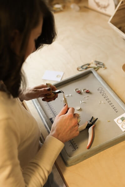 person working with jewelry making tools at a workbench 