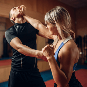 woman practicing self defense against a male attacker
