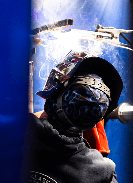 person welding a plate upside down