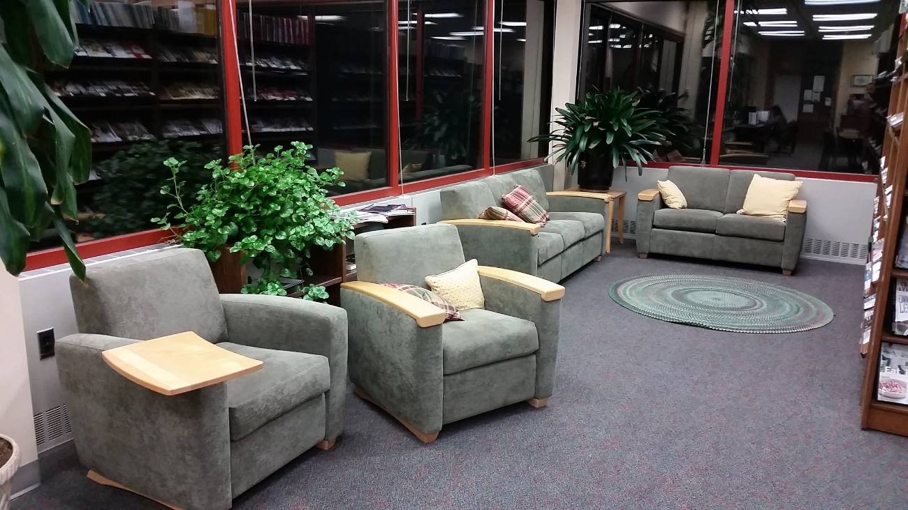 picture of an area with a couch and two stuffed study chairs in the corner of the library