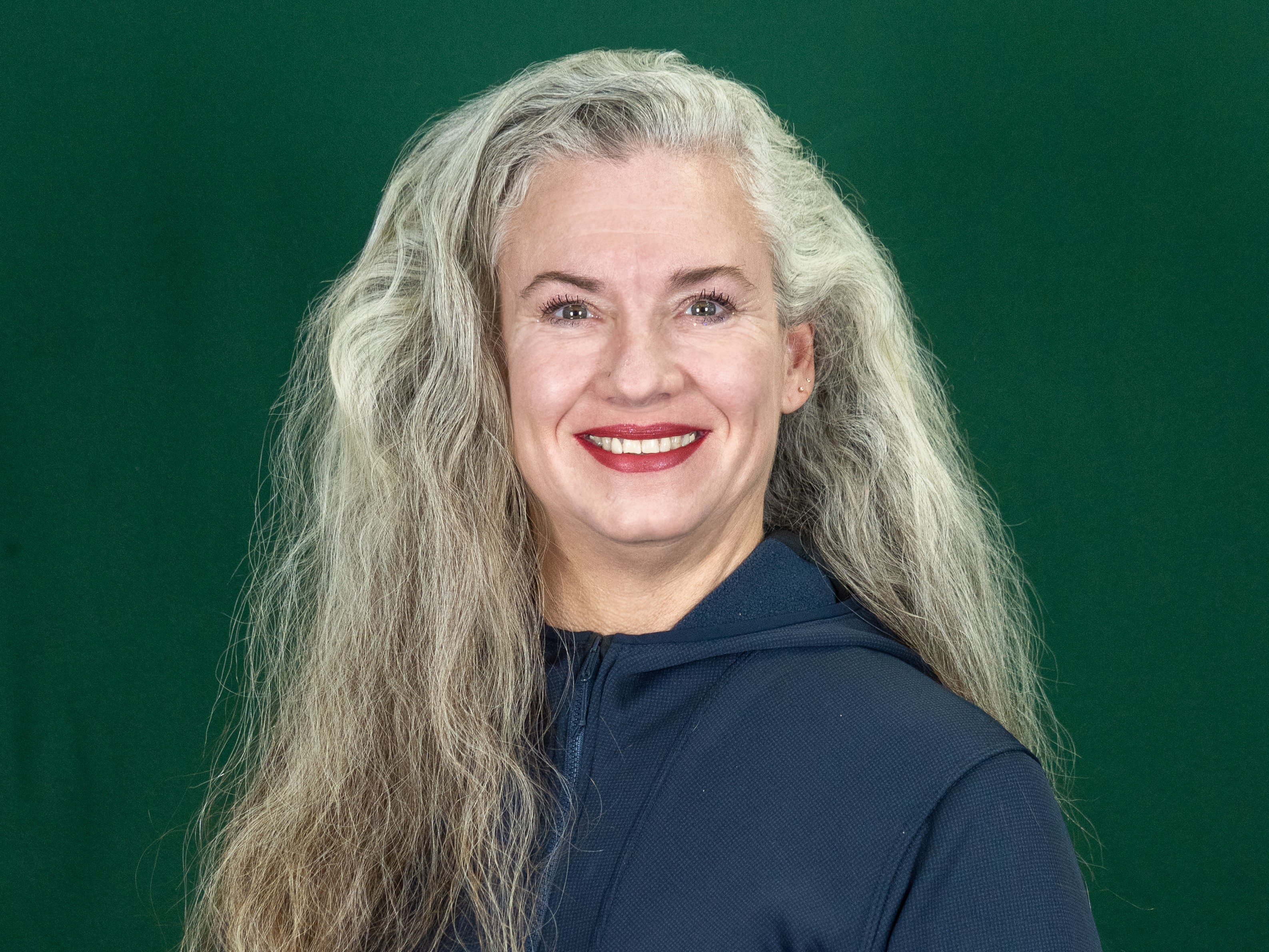 Woman in black top with a green background