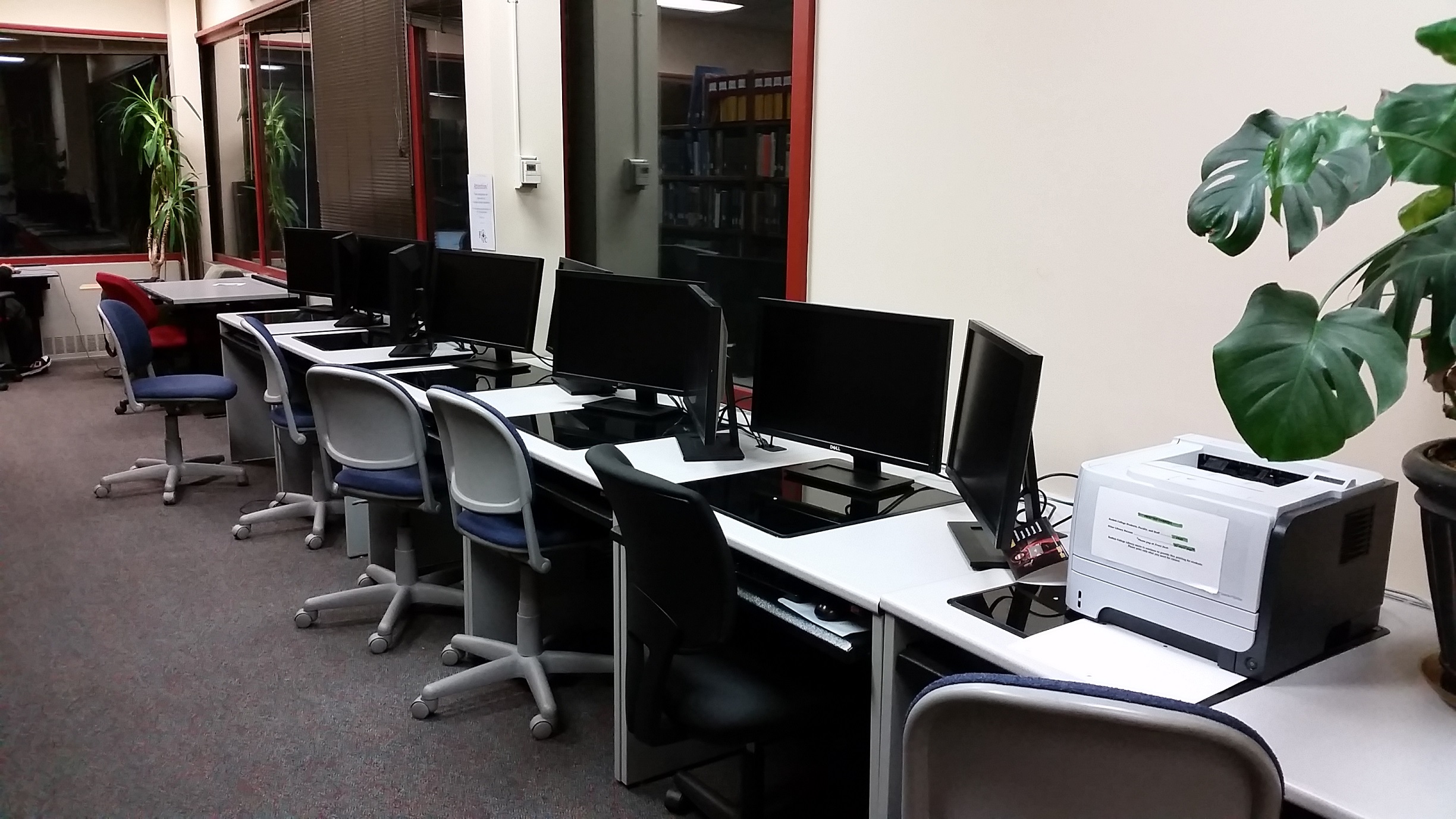 picture of 5 double-screen computer workstations and a printer in the rear of the library