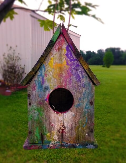 A painted birdhouse hanging outside