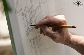a person's hand drawing on a vertical board