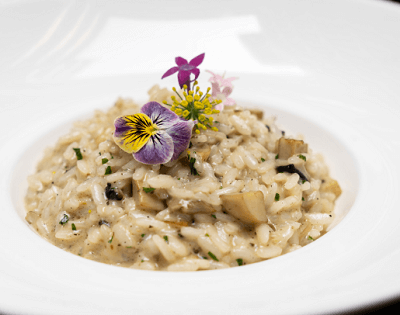 bowl of risotto garnished with purple flowers
