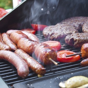 hamburgers and hot dogs on a hot grill