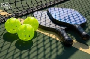 two pickleball paddles on a court in front of a net