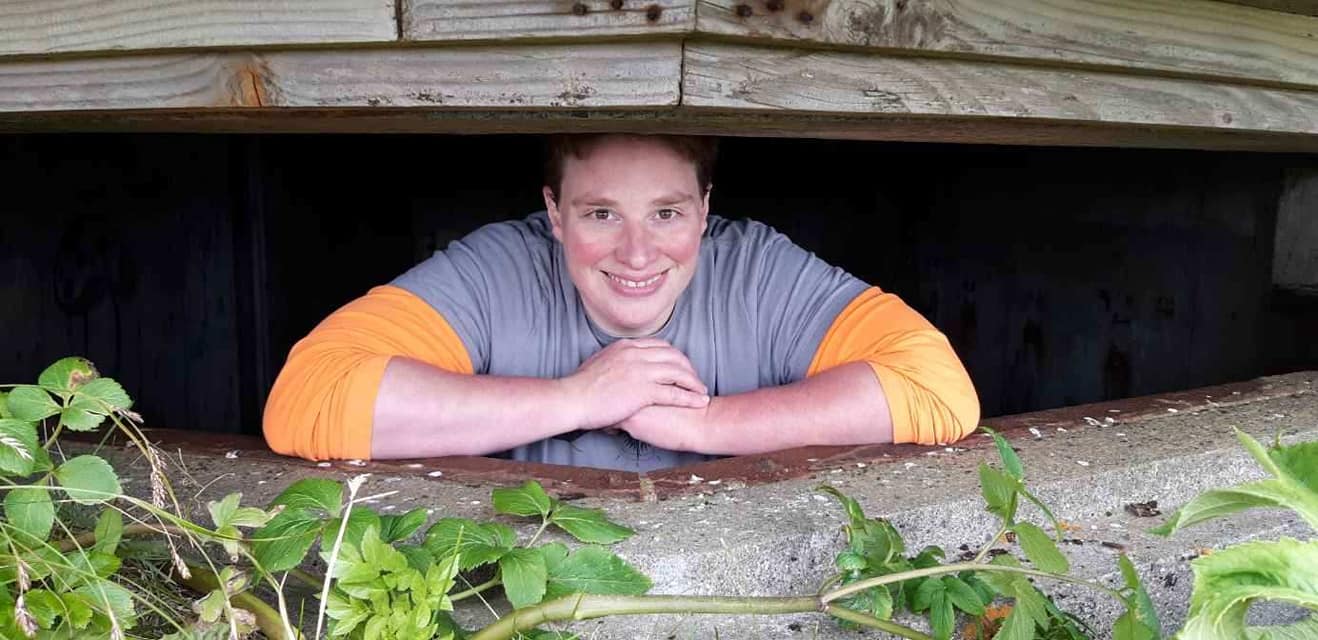 Kat Gambling looking out of a old WWII bunker in the forest