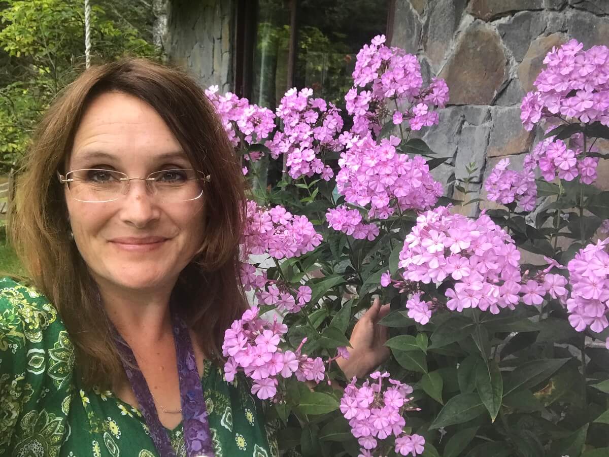 woman standing in front of pink flowers
