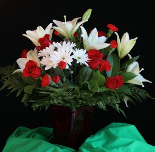 red, white, and green floral arrangement on a table